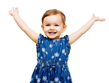 very happy toddler girl with arms outstretched up and a victorio