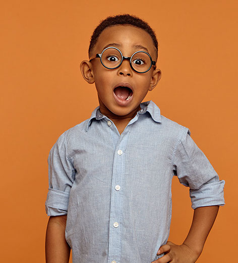 Isolated picture of handsome emotional bug eyed dark skinned schoolboy wearing stylish glasses expressing shock, keeping mouth wide opened. Excitement, fascination and true genuine emotions