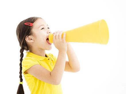 happy little girl shouting by megaphone
